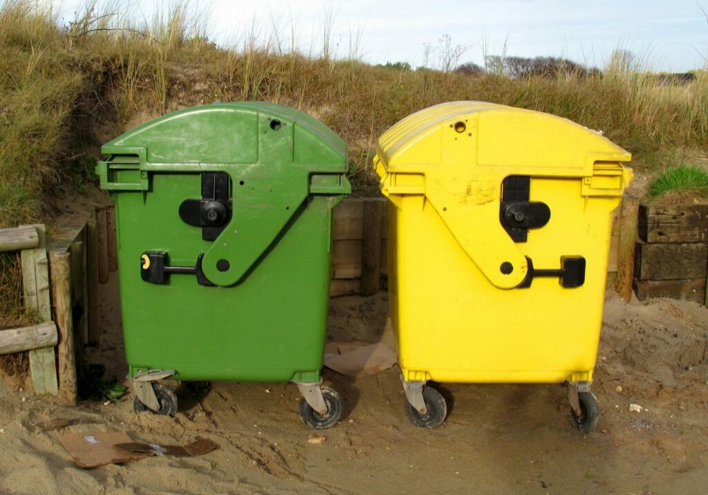two dumpsters in the sand